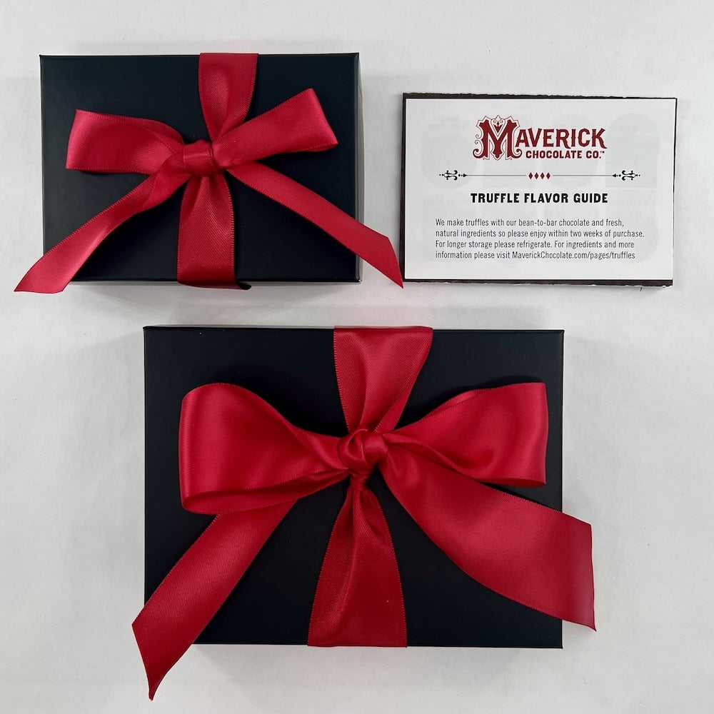 Two black chocolate boxes with red bows and a Maverick Chocolate Co. flavor guide on a light gray background.